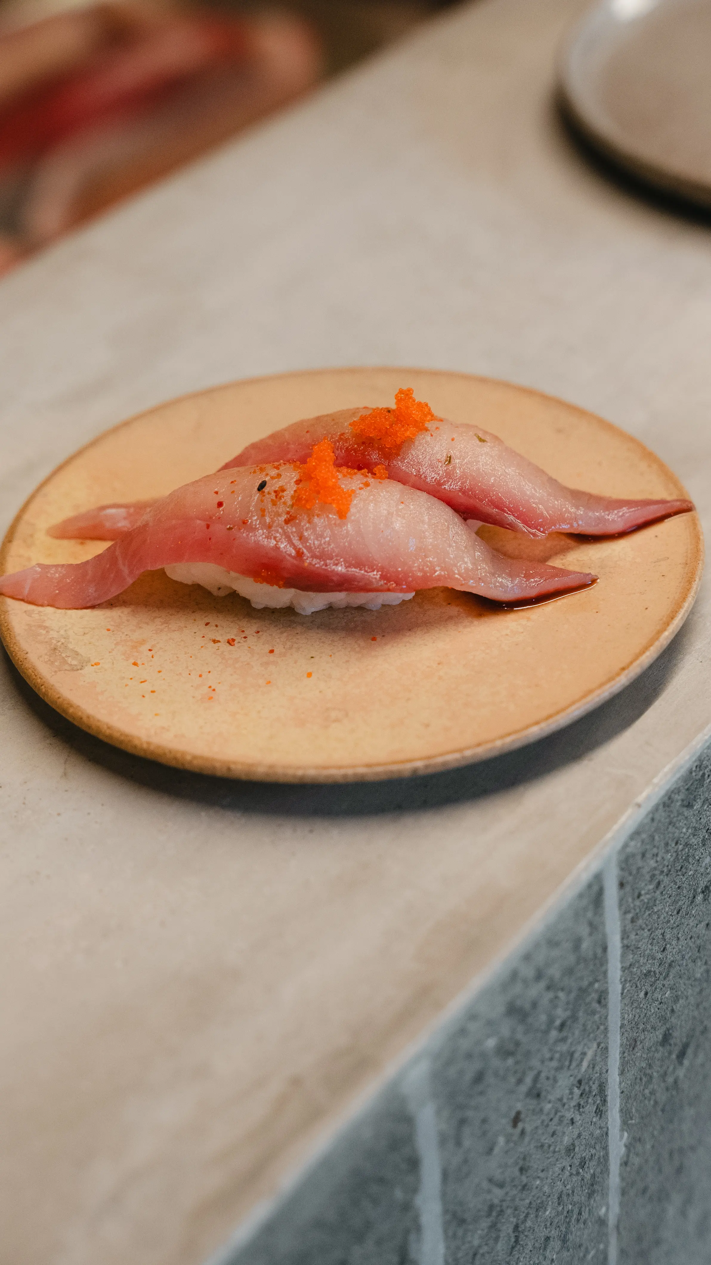 Mahi-mahi nigiri with lemon ponzu, togarashi, and masago at Yasumi